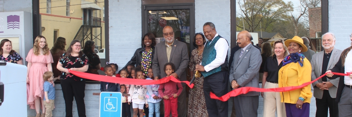 Annie Thompson Jeffers Library grand opening showing a group of people cutting a red ribbon