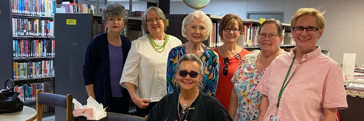 Group of adults smiling while inside the library