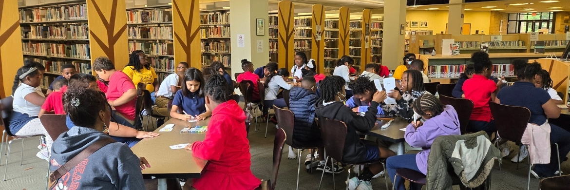 Library room full of children of all ages during a program