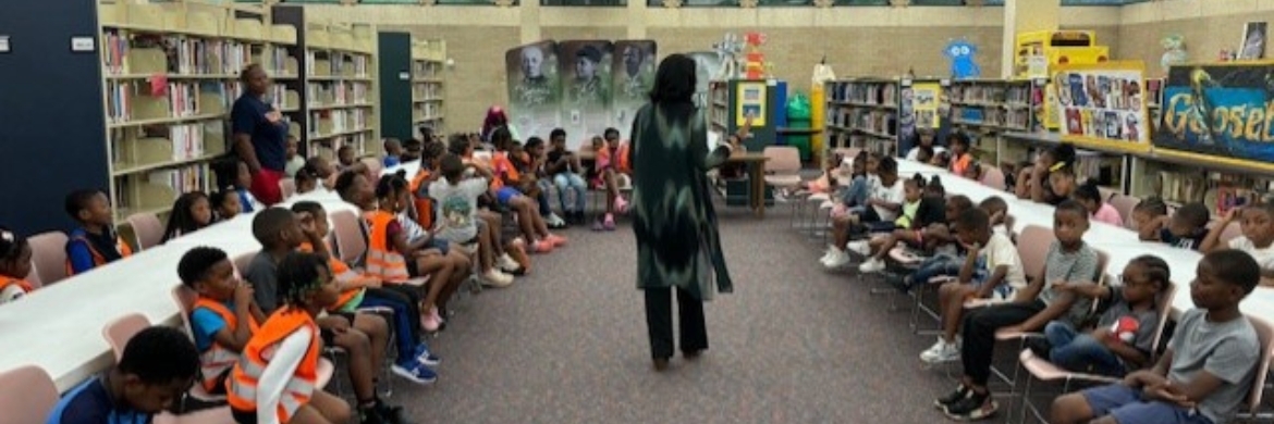 Room full of children and two librarians at the Medgar Evers Library