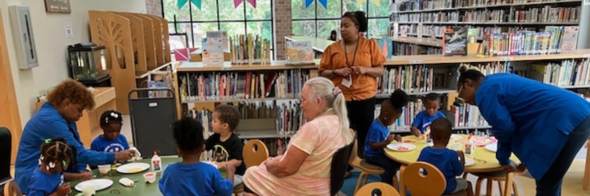 Group of adults and children in the library during an arts and crafts event