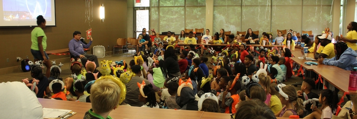 Storytime event at the Quisenberry Library showing a room full of children and a librarian at the front with a book