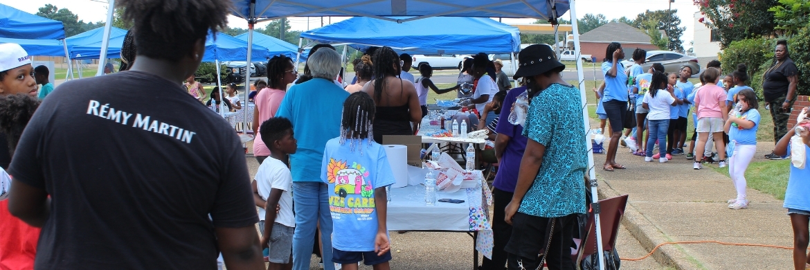 Group of people standing at a table at an outdoor event